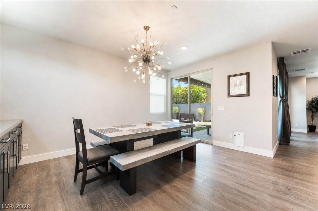 2166 Trivero Street Henderson, NV 89044 - Photo 10 of 61 Illuminated by a contemporary chandelier, this dining area flows effortlessly to an outdoor courtyard through glass sliders.