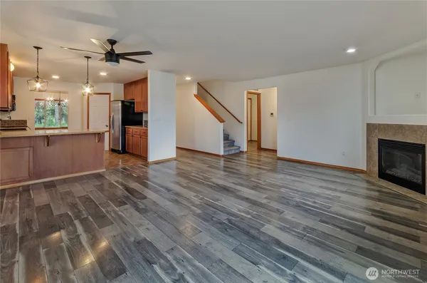 a view of a kitchen with wooden floor and a fireplace