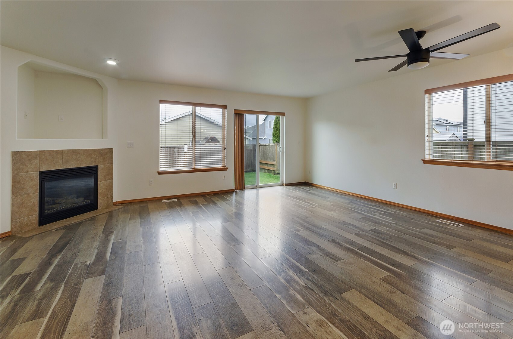 9114 Canal Road Southeast Yelm, WA 98597 - Photo 14 of 40 an empty room with wooden floor fireplace and windows