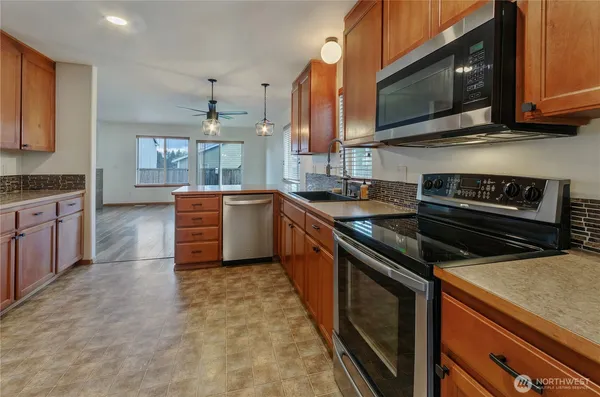 a kitchen with stainless steel appliances granite countertop a stove top oven a sink dishwasher and microwave oven