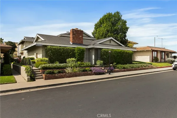 a front view of a house with a garden and plants