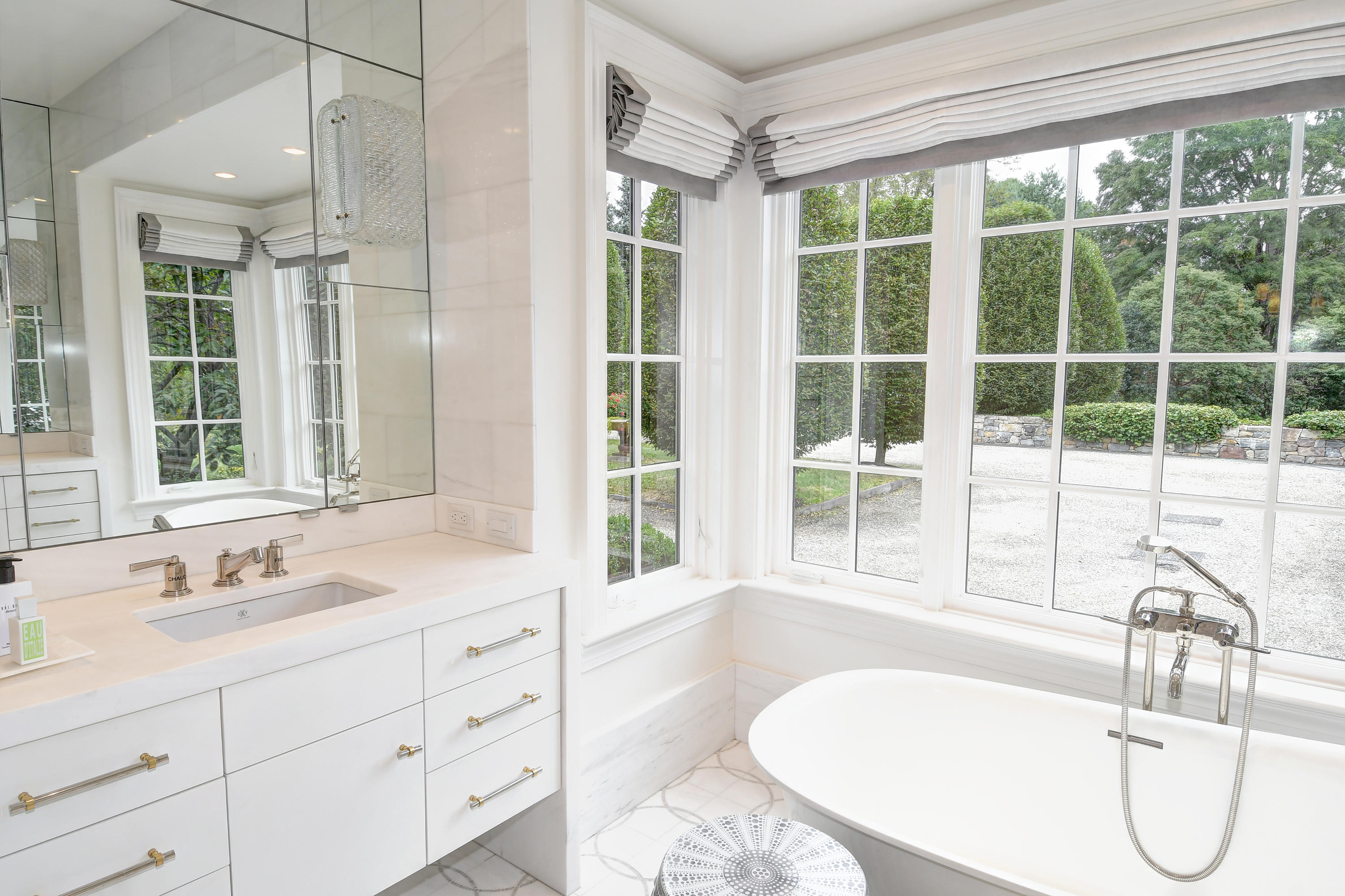 507 Silvermine Road New Canaan, CT 06840 - Photo 26 of 40 a bathroom with a tub sink a mirror and next to a window