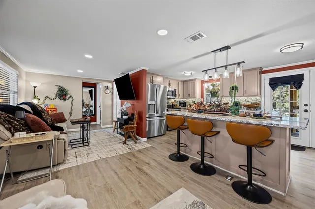 a living room with lots of furniture and kitchen view