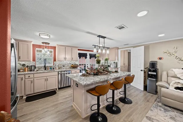 a kitchen with sink cabinets and dining table chair
