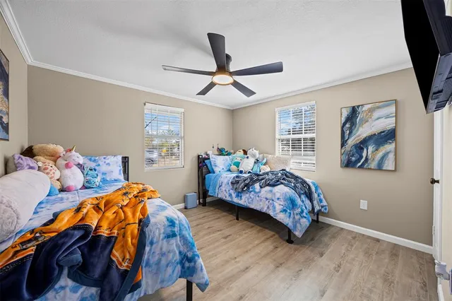 a bedroom with a bed painting on wall and a large window