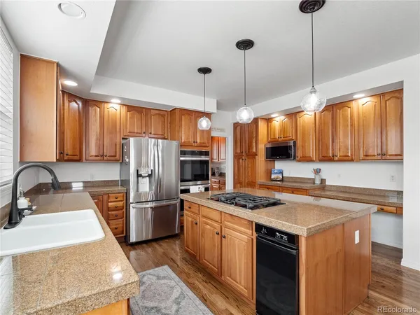 a kitchen with stainless steel appliances granite countertop a sink stove and refrigerator