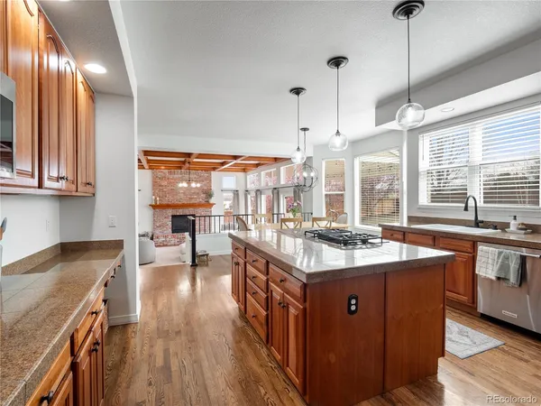 a kitchen with kitchen island granite countertop a stove and a wooden floors