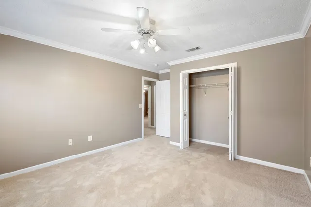 a view of an empty room with a chandelier fan