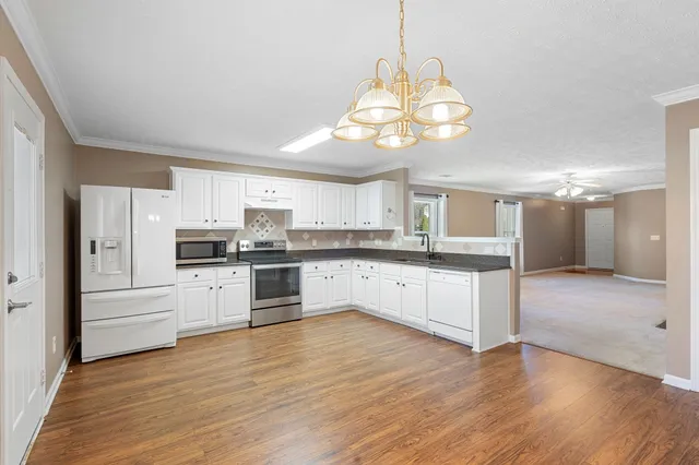 a large kitchen with cabinets wooden floor and stainless steel appliances