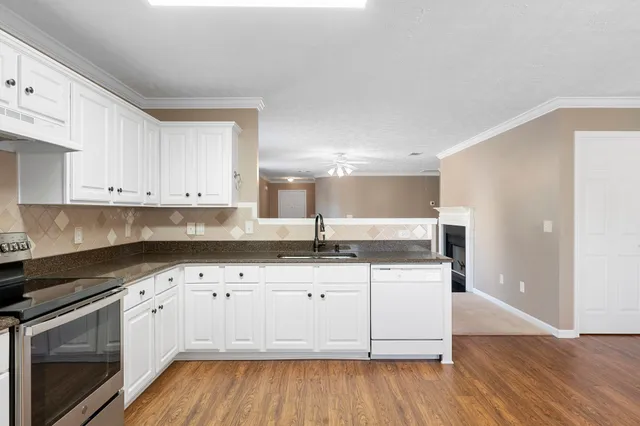 a kitchen with granite countertop a sink and cabinets with wooden floor