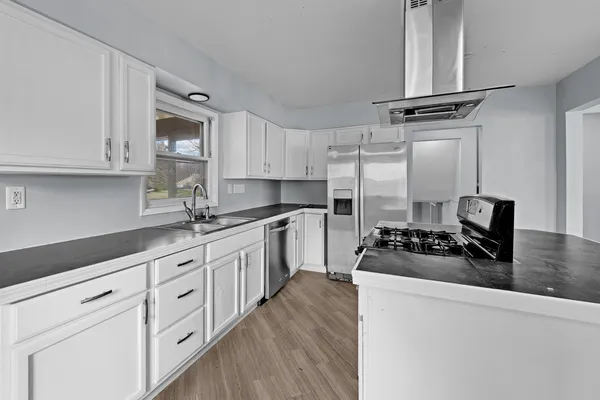 a kitchen with cabinets appliances a sink and a counter top space