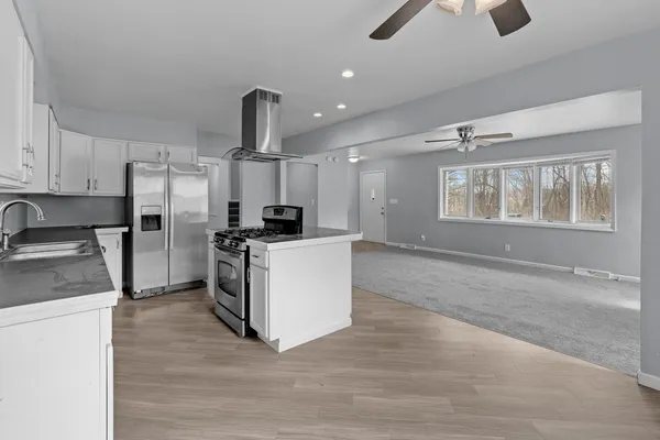 a kitchen with stainless steel appliances kitchen island a refrigerator sink and stove