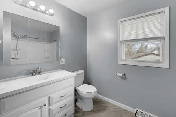 a bathroom with a toilet a sink and mirror