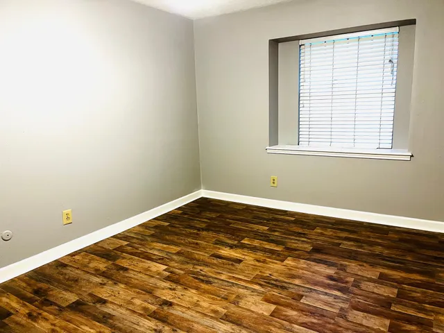 a view of a room with wooden floor and a window