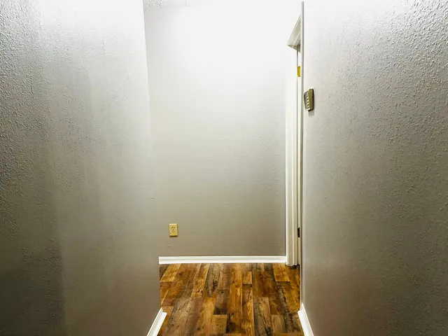 a view of a hallway with wooden floor