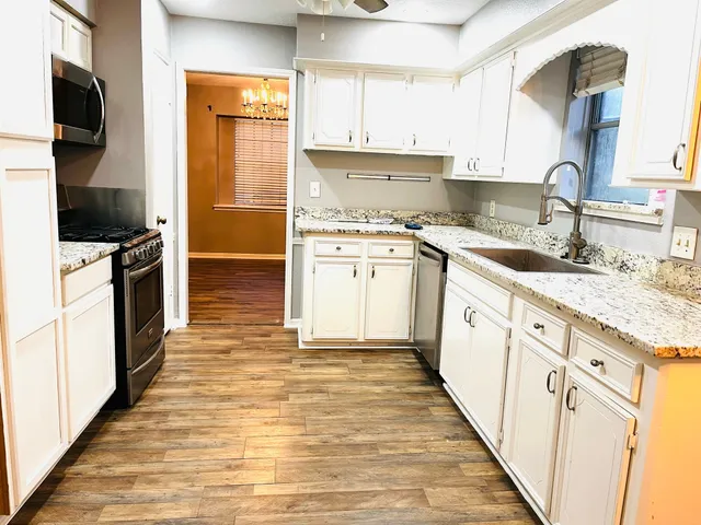 a kitchen with granite countertop a sink and cabinets