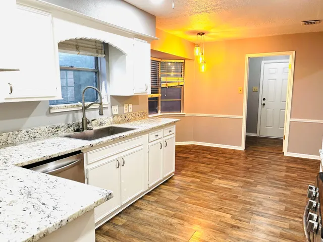 a kitchen with granite countertop a sink and cabinets