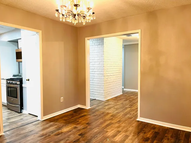 a view of a room with a window and wooden floor