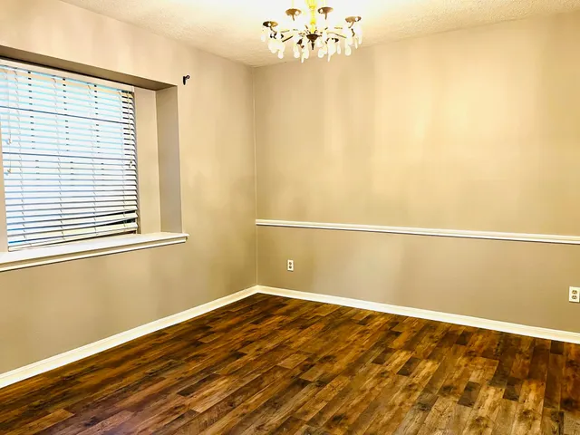 a view of a room with wooden floor and a window