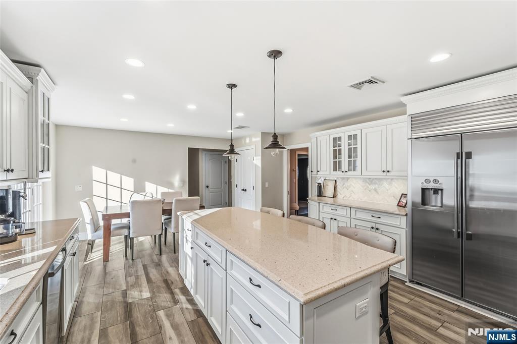 27 Pine Hill Road Old Tappan, NJ 07675 - Photo 15 of 50 a kitchen with stainless steel appliances a table chairs refrigerator and cabinets