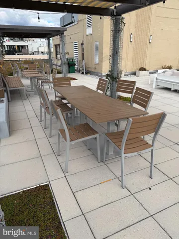 a roof deck with couches and potted plants