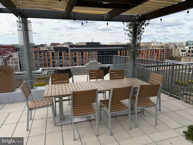 a roof deck with couches and potted plants