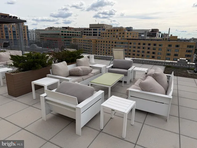 a view of a terrace with lawn chairs and iron fence