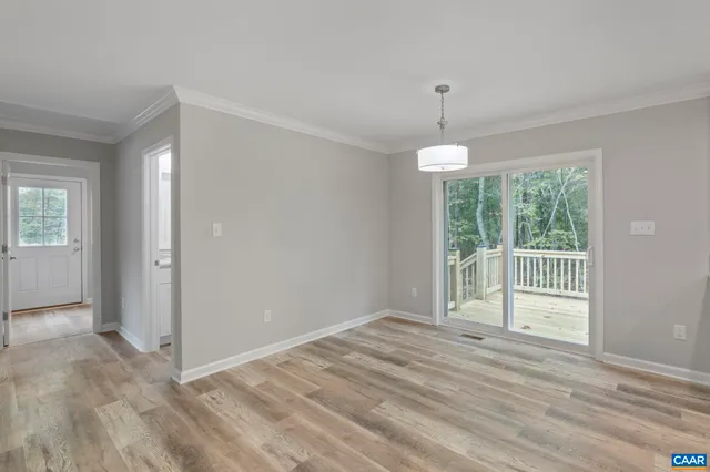 a large white kitchen with a large island oven a sink stainless steel appliances and a chandelier