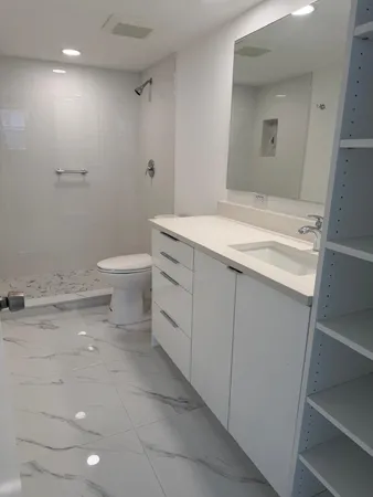 a bathroom with a sink a toilet and a mirror