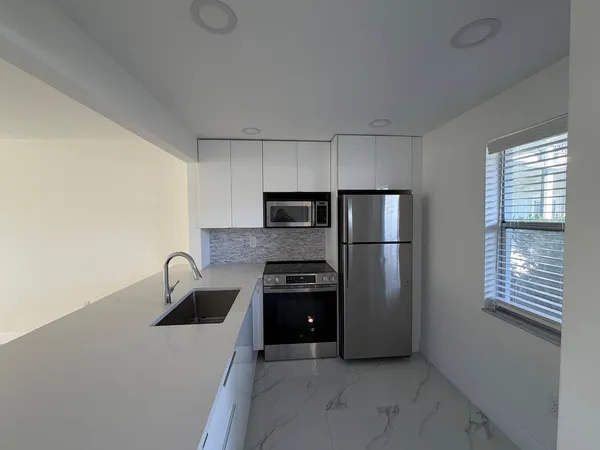 a kitchen with a refrigerator and a sink
