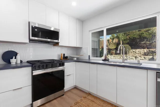 a kitchen with stainless steel appliances granite countertop a sink and a stove