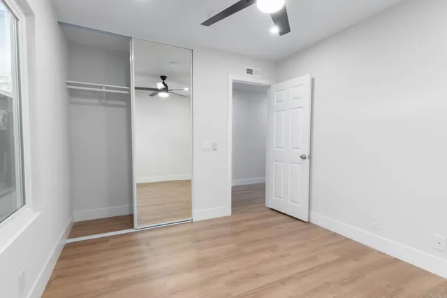 an empty room with a window and a fan