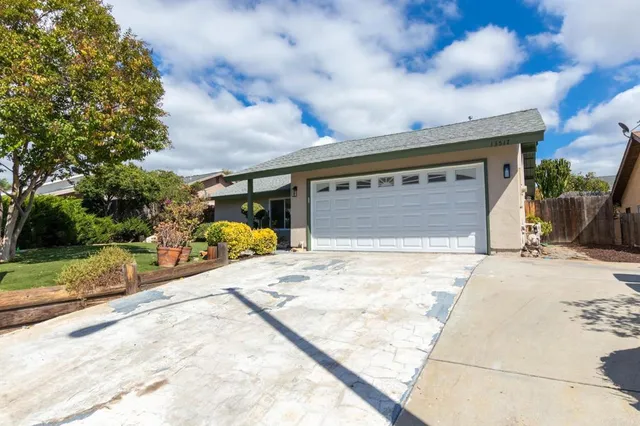 a front view of house with yard and trees in the background