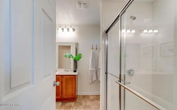 a bathroom with a granite countertop shower a sink and a mirror