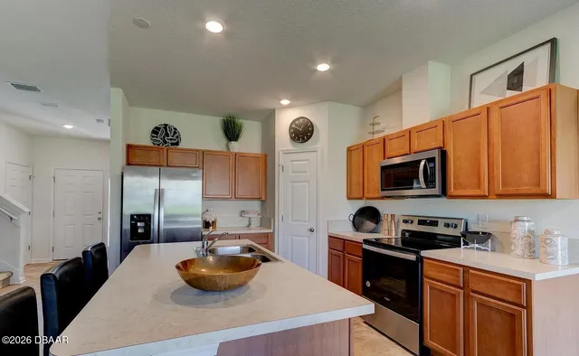 a kitchen with stainless steel appliances a stove a sink a microwave and cabinets