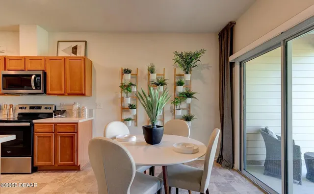 a dining room with furniture and potted plant