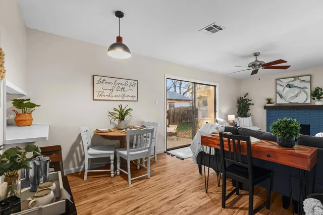 a dining room with wooden floor a chandelier a wooden table and chairs