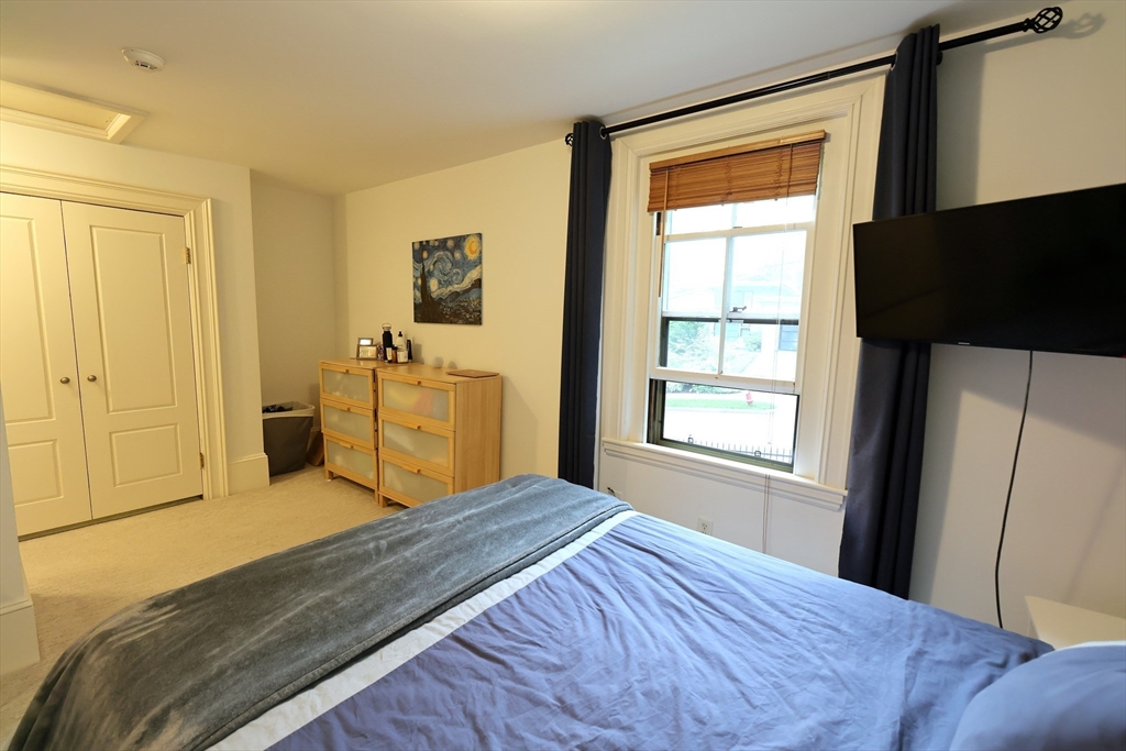 107 Waban Hill Road, Unit R Newton, MA 02467 - Photo 16 of 21 a bedroom with a bed and a dresser next to a window
