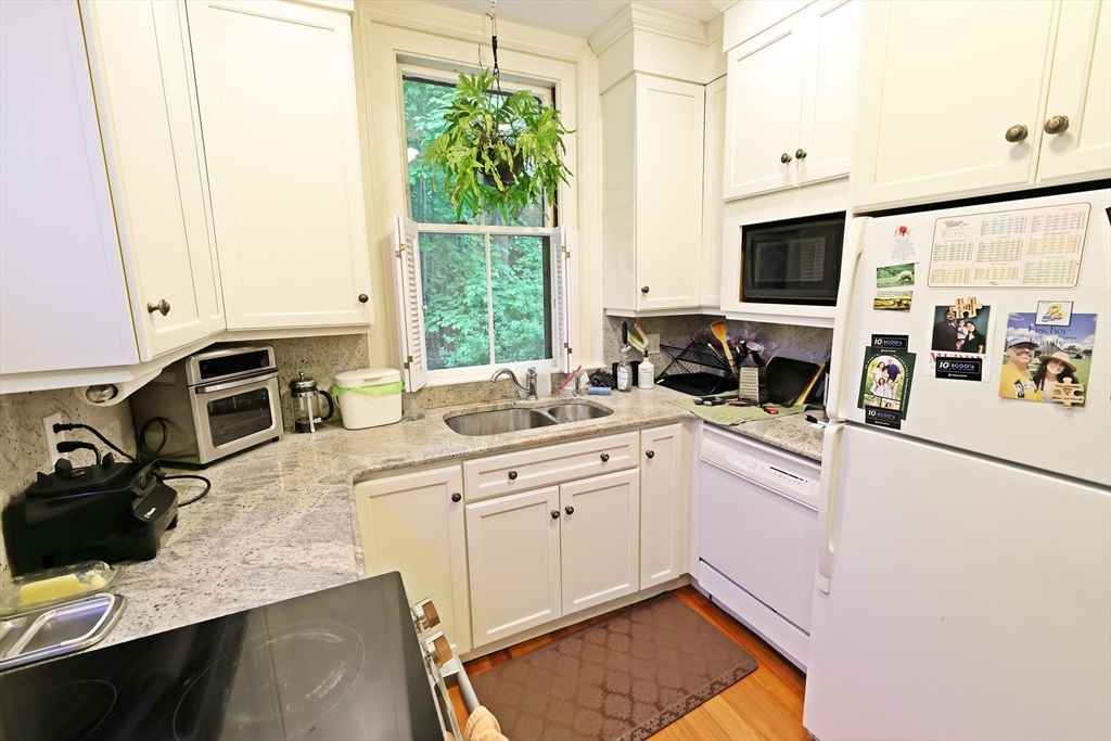 107 Waban Hill Road, Unit R Newton, MA 02467 - Photo 2 of 21 a kitchen with a sink stove and white cabinets