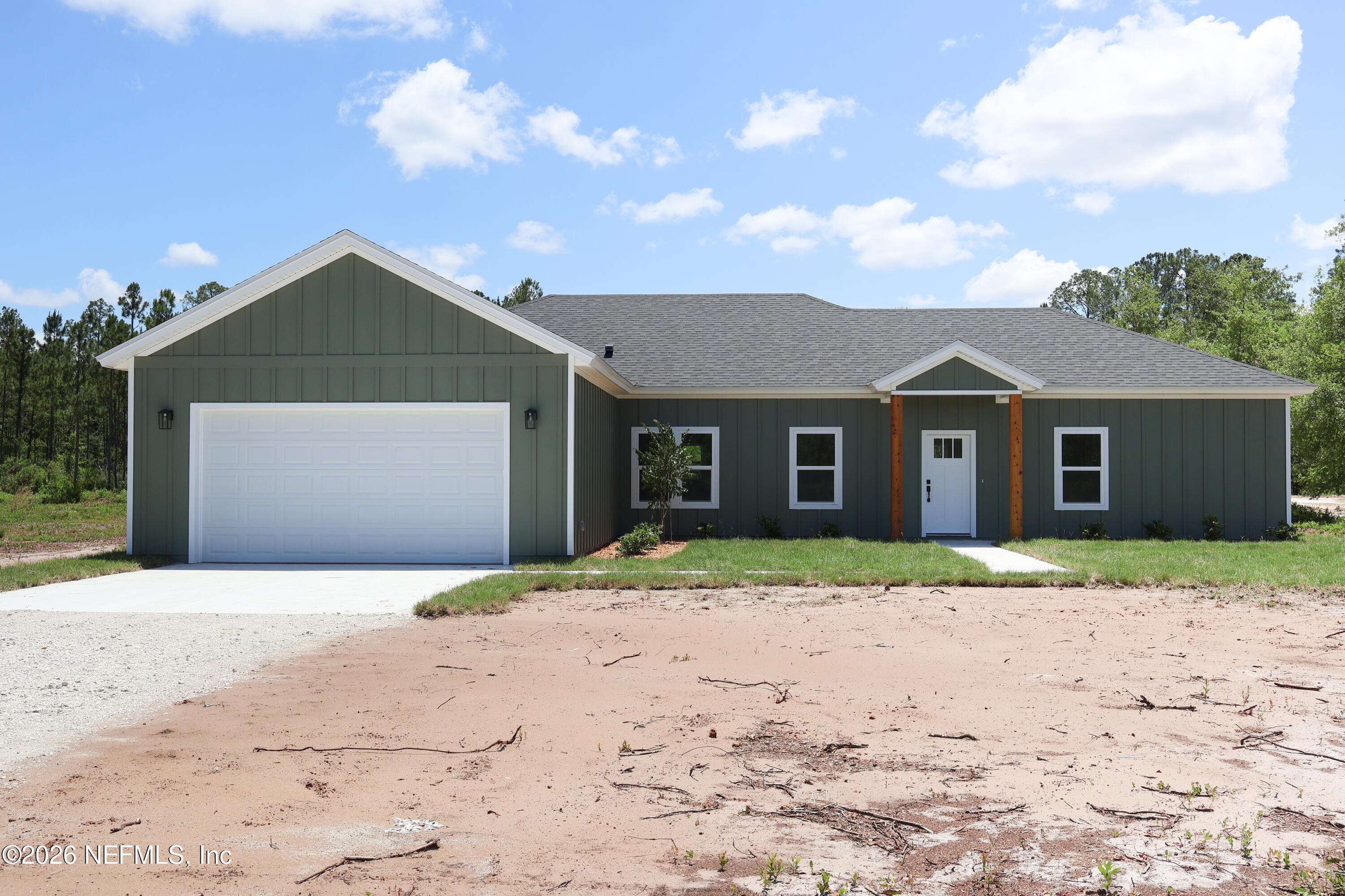 261121 Rowe Road Hilliard, FL 32046 - Photo 1 of 33 a front view of a house with a yard and garage
