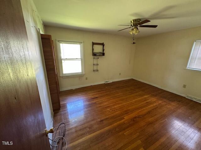 706 Orchard Drive Graham, NC 27253 - Photo 13 of 18 an empty room with wooden floor fan and windows