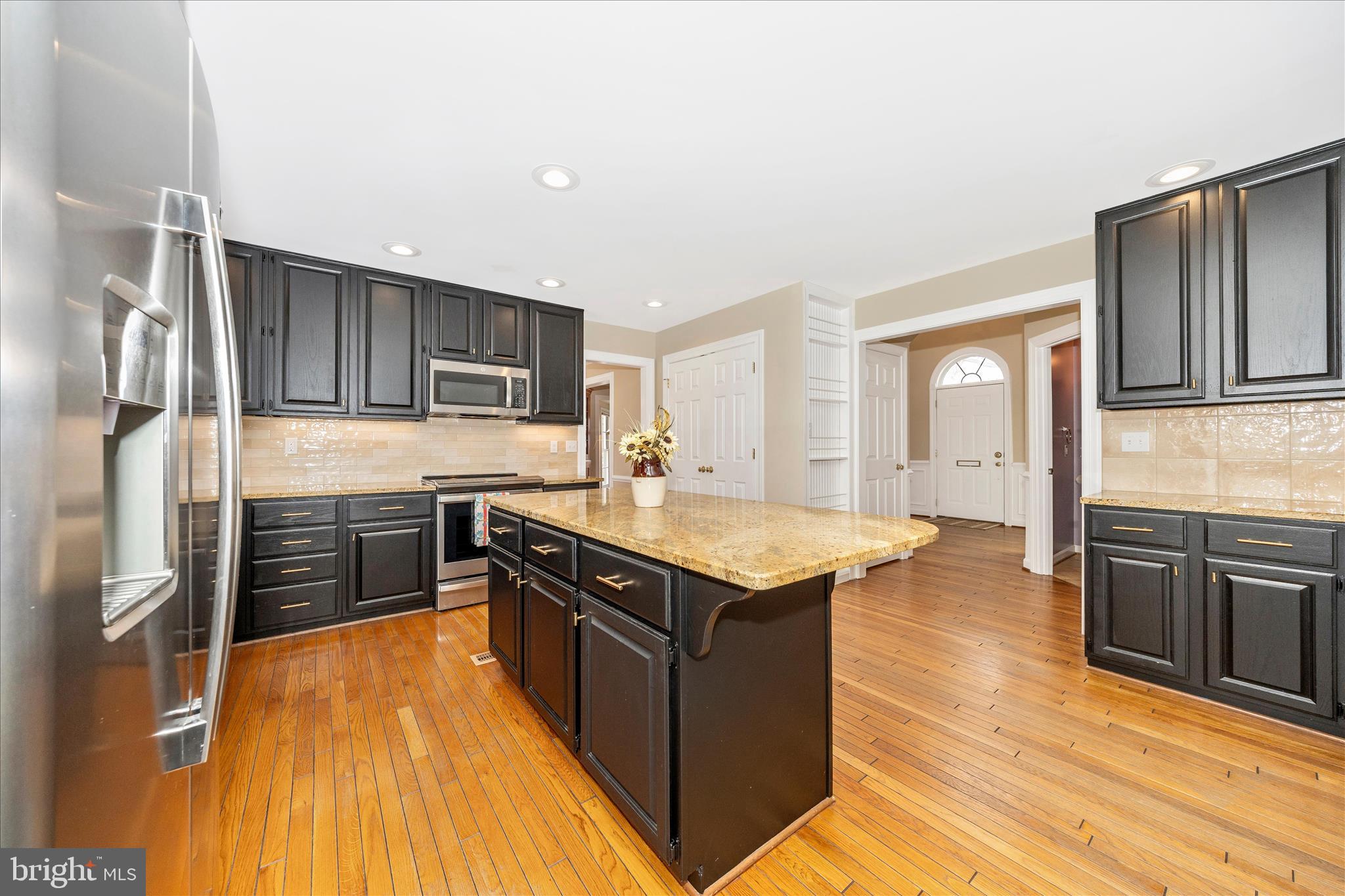 6135 Cornwall Place Frederick, MD 21701 - Photo 16 of 81 a kitchen with stainless steel appliances granite countertop a stove top oven a sink dishwasher and wooden cabinets with wooden floor