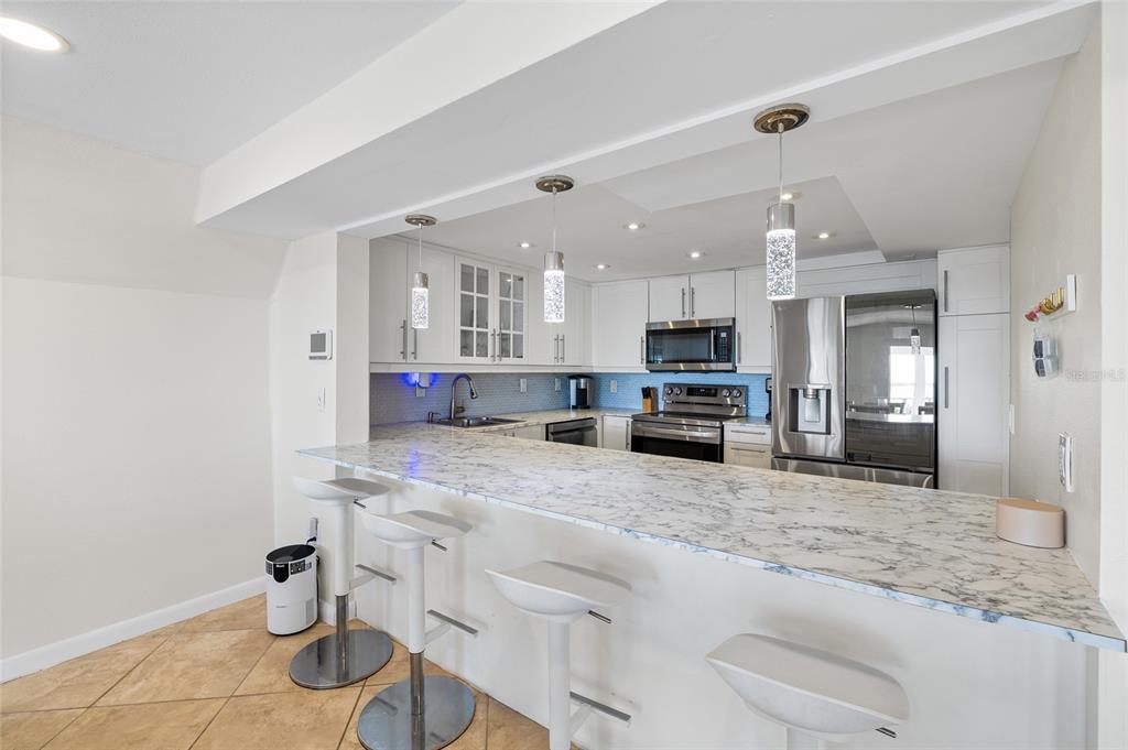 9664 Privateer Road Boca Grande, FL 33921 - Photo 14 of 66 a kitchen with stainless steel appliances kitchen island granite countertop a sink and cabinets
