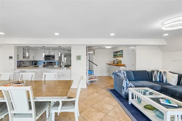 a living room with furniture and a dining table with kitchen view