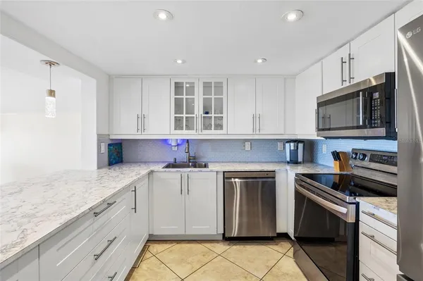 a kitchen with granite countertop white cabinets and white appliances