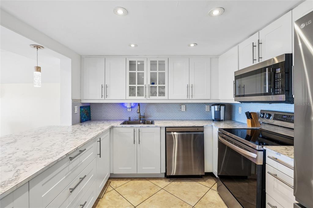 9664 Privateer Road Boca Grande, FL 33921 - Photo 21 of 66 a kitchen with granite countertop a sink stainless steel appliances and cabinets
