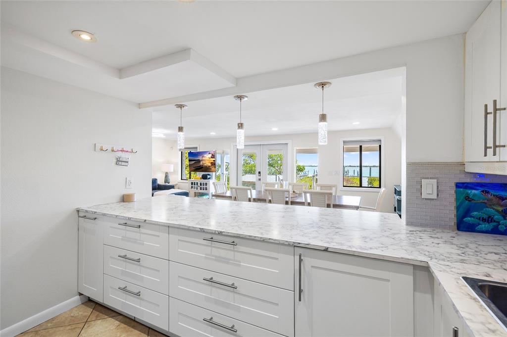 9664 Privateer Road Boca Grande, FL 33921 - Photo 22 of 66 a view with granite countertop a sink flowers in it and cabinets