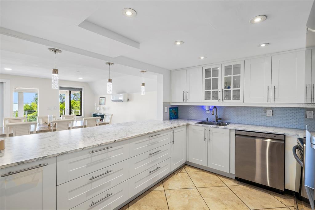 9664 Privateer Road Boca Grande, FL 33921 - Photo 24 of 66 a kitchen with granite countertop white cabinets and white appliances