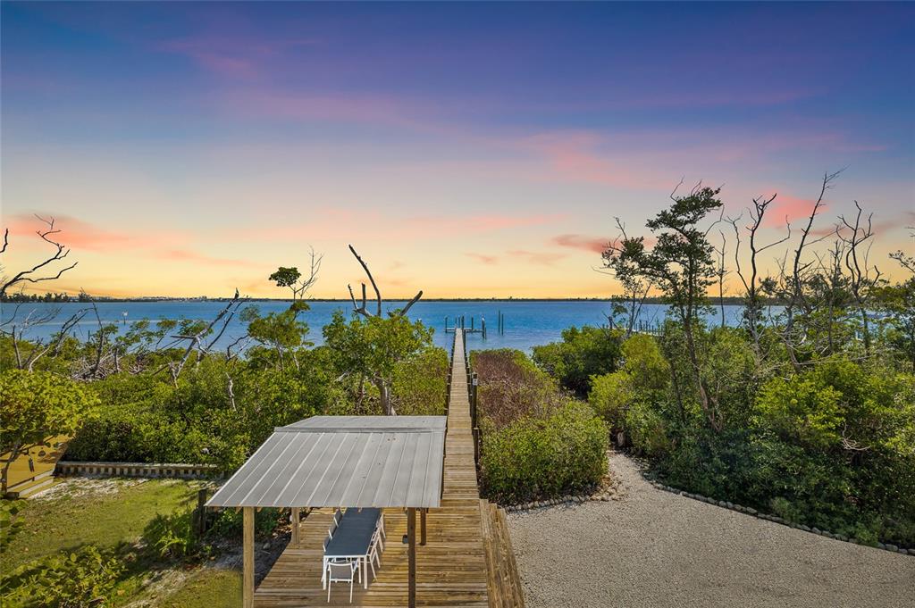 9664 Privateer Road Boca Grande, FL 33921 - Photo 7 of 66 a view of a house with pool and trees in the background