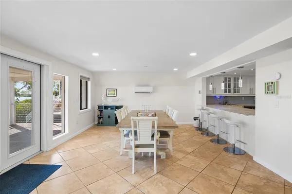 a dining area with stainless steel appliances kitchen island granite countertop a dining table chairs and view living room